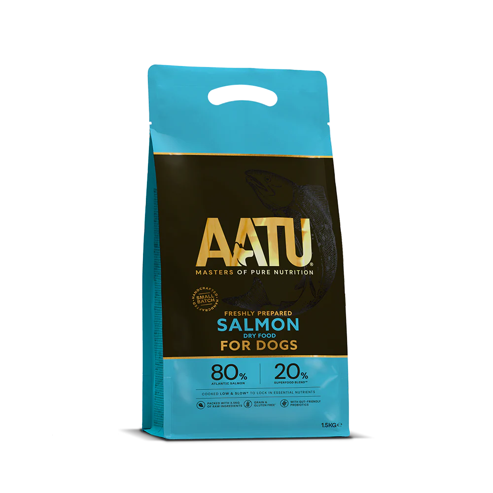 There is a bag of AATU Salmon Dry Dog Food. It is a front view of the packaging and the bag is blue with a dark band in the middle. The wording AATU is embellished in gold font on the front of the bag with the tag line 'Masters of pure nutrition'. The bag has a little handle at the top and it is marked as a 1.5kg bag.