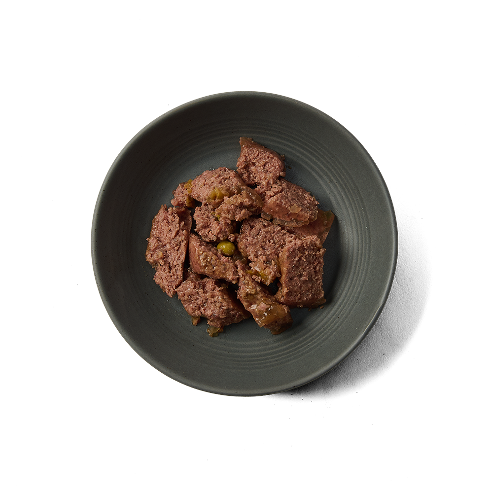 Top view of Dinky Dog Turkey & Pheasant wet dog food in a bowl, showcasing grain-free recipe with visible meat and vegetables.